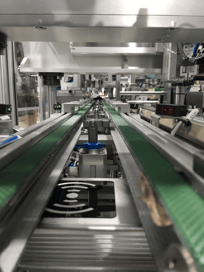 Lector de escritorio RFID UHF JT-6230 utilizado en una línea de producción industrial para el seguimiento y la identificación automatizados de piezas.