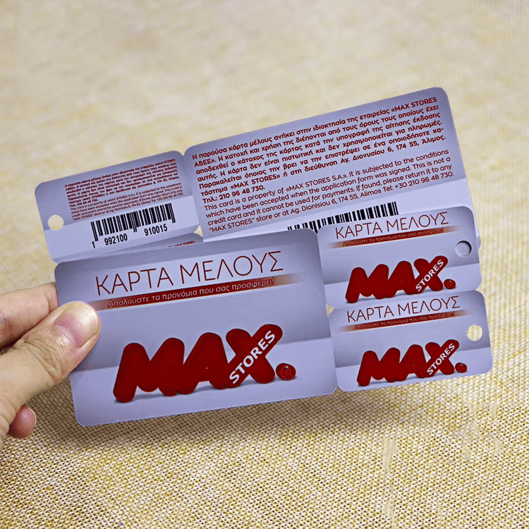 Un conjunto de tarjetas de regalo combinadas de plástico sostenido en la mano muestra las etiquetas desprendibles y la impresión clara para promociones comerciales y regalos.