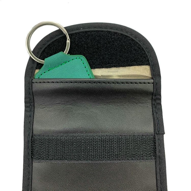 La clásica bolsa de bloqueo RFID de cuero marrón se presenta como accesorio profesional de viaje para proteger tarjetas bancarias y documentos de identidad personales.