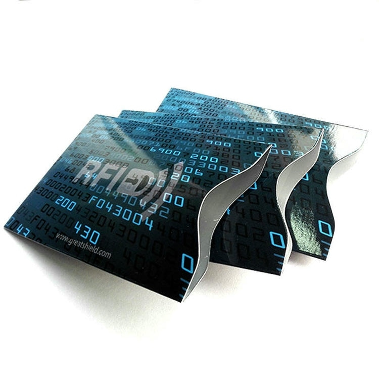 Tres fundas negras de bloqueo RFID con recortes de borde azul mostradas como insertos delgados para protección antirrobo de tarjetas en cartera
