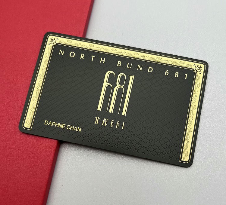 Tarjeta de visita metálica con impresión en negro y dorado y un diseño enmarcado para categorías de acceso VIP sofisticadas.
