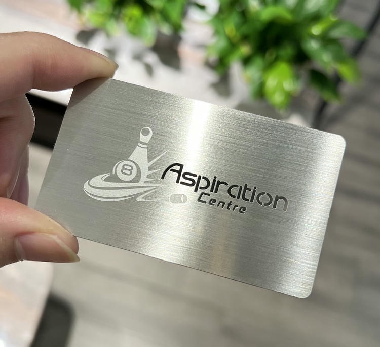 Tarjeta de visita metálica con textura de acero inoxidable cepillado y logotipo grabado para una identidad de marca duradera.