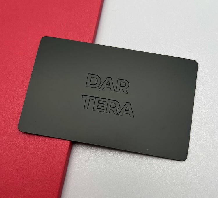 Tarjeta de visita metálica con superficie negra mate y letras grabadas en profundidad para una identidad minimalista y exclusiva.