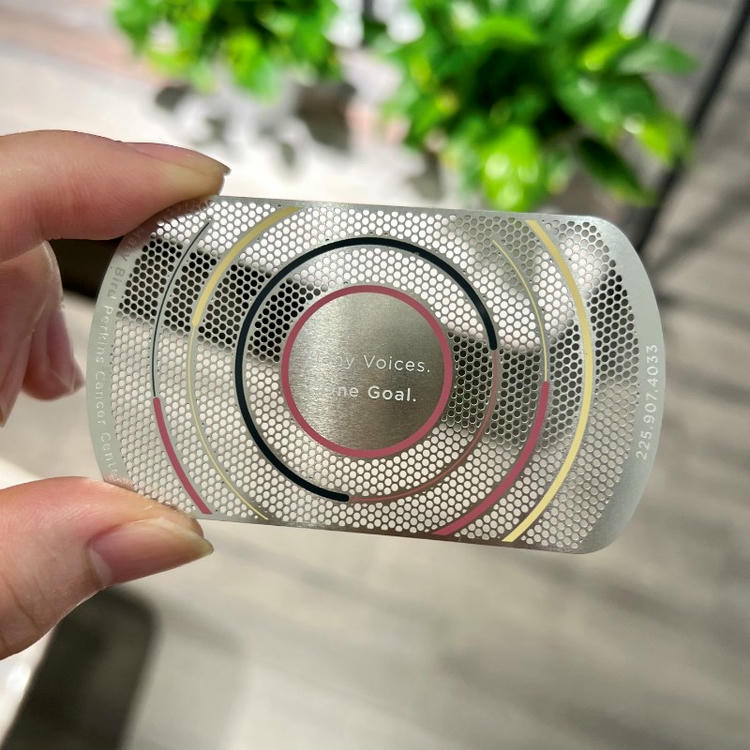 Esta tarjeta de visita metálica muestra un patrón plateado de círculos perforados con anillos superpuestos para un diseño moderno de acceso VIP.