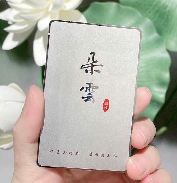Tarjeta de visita metálica con superficie satinada plateada e impresión de caligrafía china para una imagen de marca exclusiva y refinada.