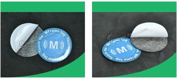 La etiqueta RFID D35mm apta para metal se muestra con su capa posterior blanca parcialmente abierta para mostrar la estructura adhesiva y la forma redonda de la etiqueta.
