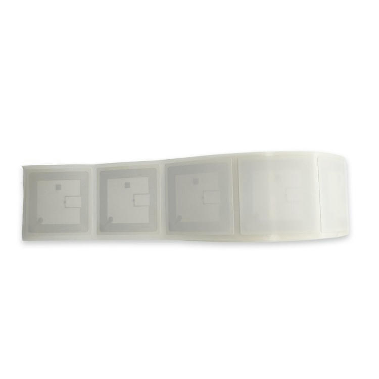 Tira horizontal de etiquetas RFID para libros con varios inlays cuadrados seguidos de secciones de etiqueta en blanco dentro del mismo rollo.