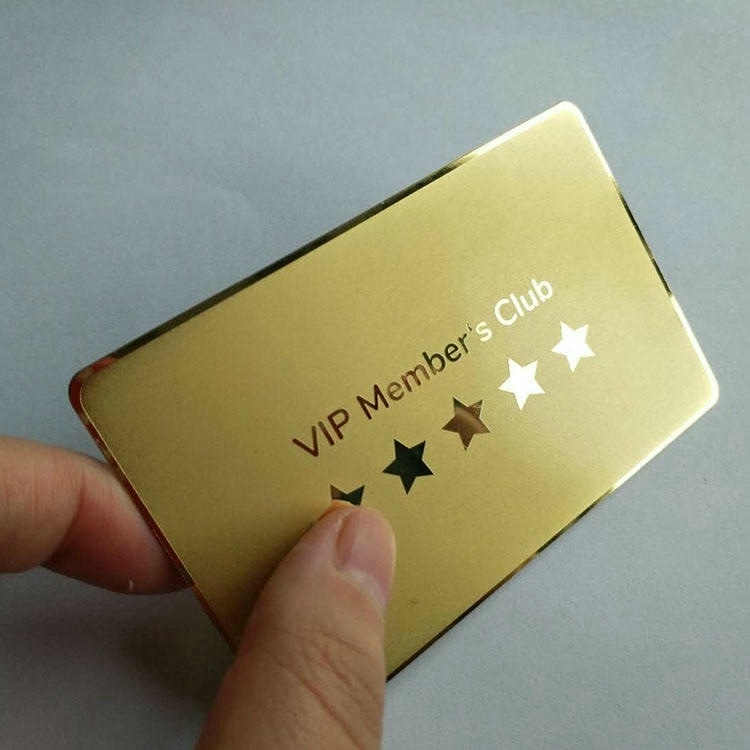 Una tarjeta de metal dorado VIP Members Club fotografiada en ángulo muestra troquelados de estrellas y bordes pulidos.