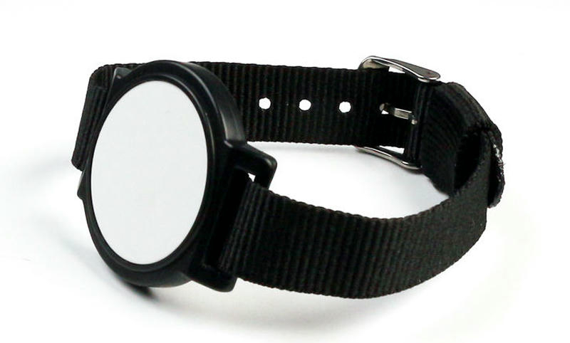 Asistentes utilizando pulseras RFID de nailon NLWB-04 para agilizar el acceso a un evento concurrido.