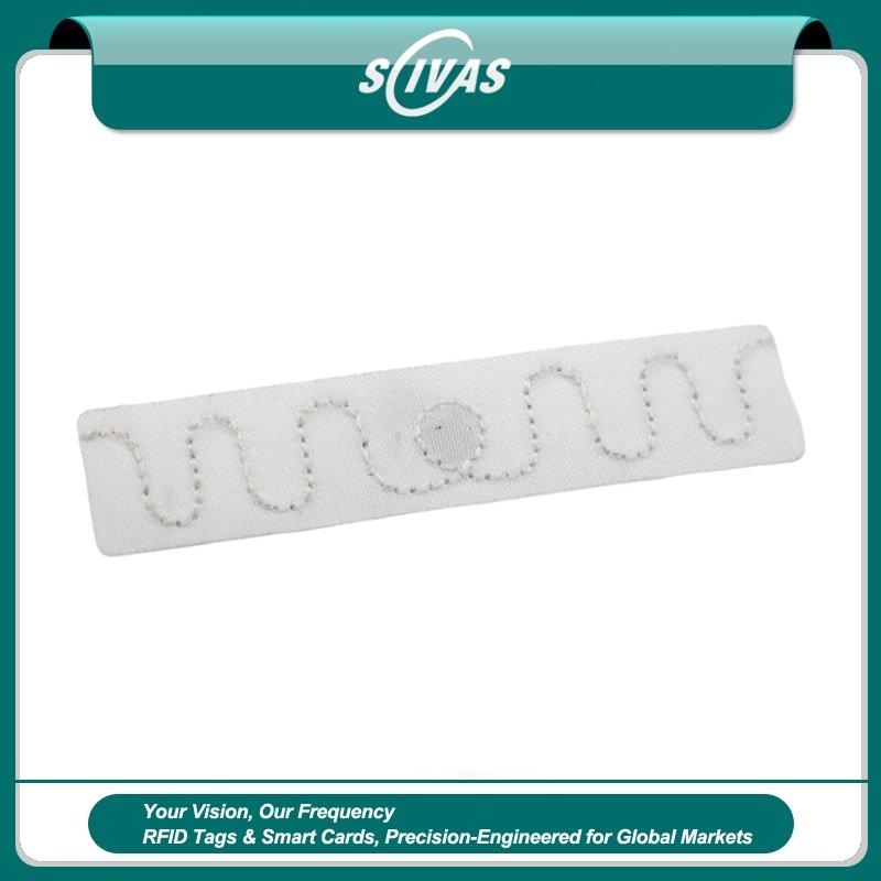 Etiqueta RFID de poliéster para lavandería SCIVAS T7015-4 mostrada en blanco con un patrón de antena UHF cosido para seguimiento duradero de ropa blanca.