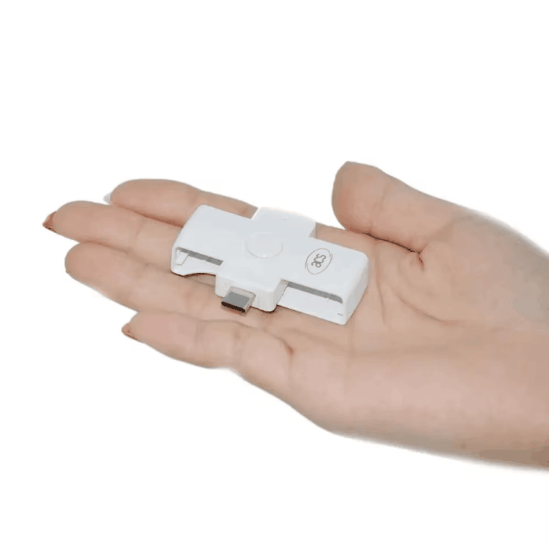 El lector de tarjetas inteligentes ACR39U-NF PocketMate II descansa sobre una mano para demostrar su tamaño compacto y portátil para viajes.