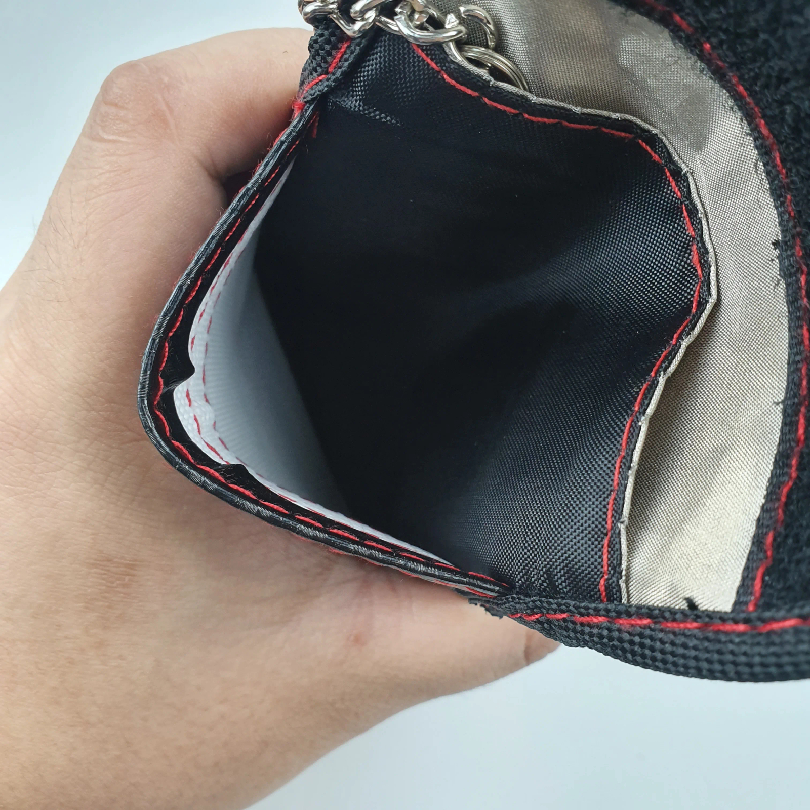 Bolsa negra de fibra de carbono con bloqueo RFID, presentada como accesorio elegante para la seguridad diaria.